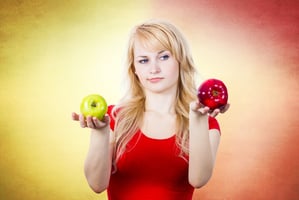 Mulher com duas maçãs de cores diferentes