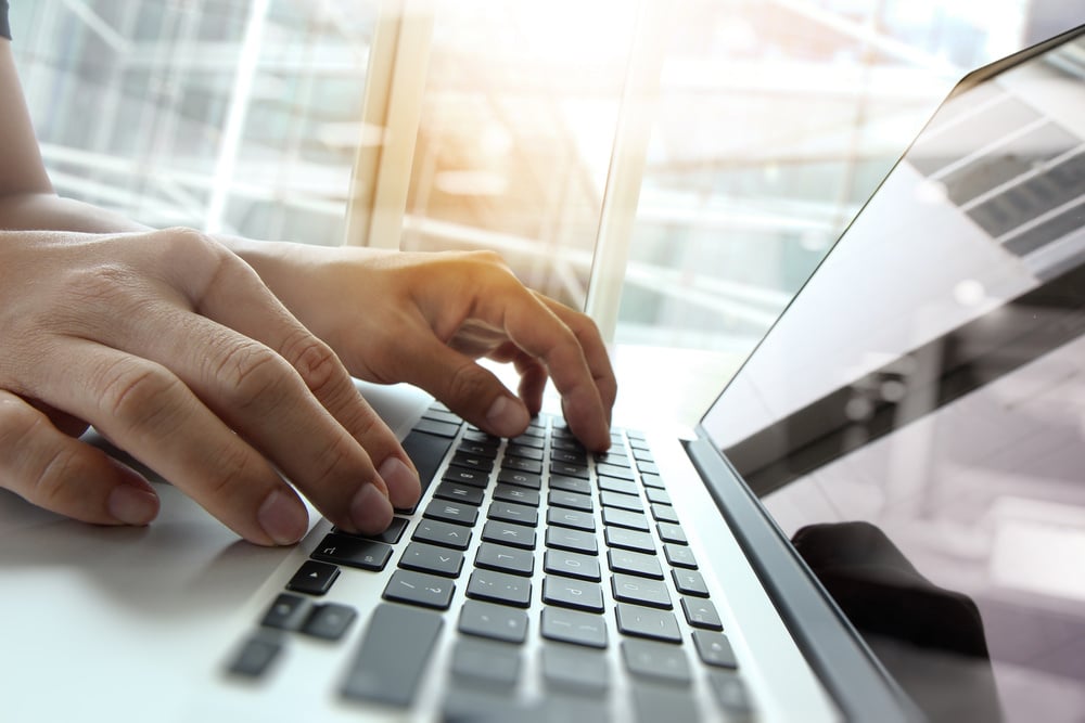 Double exposure of businessman hand working on blank screen laptop computer on wooden desk as concept